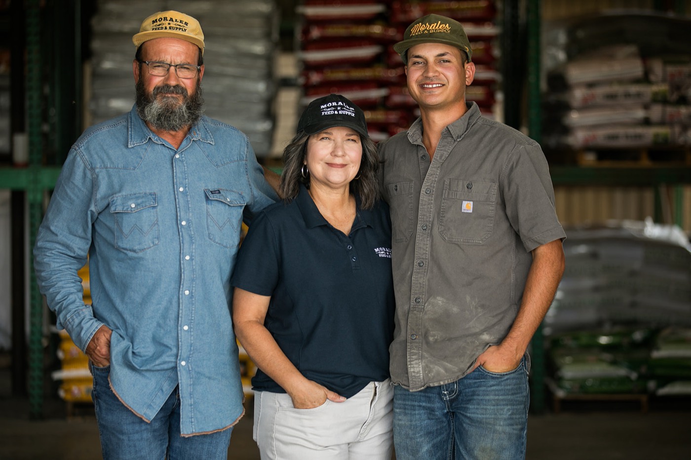 The team at Morales Feed standing in front of stacked feed pallets